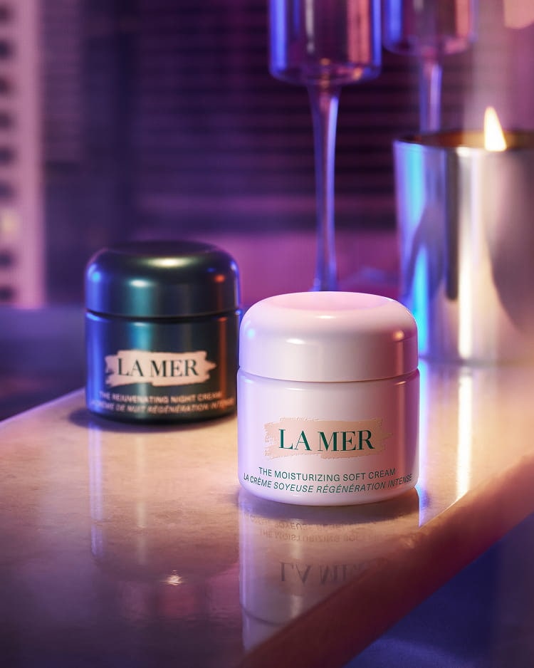 The rejuvenating night cream and the moisturizing soft cream against pink and purple gradient background 