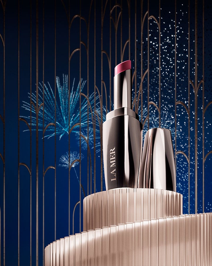 The New Lip Treatment on a elegant, gold plinth, in front of festive fireworks in the night sky