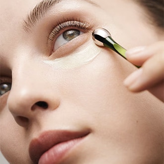 Close up of model applying The Eye Concentrate to under eyes using applicator