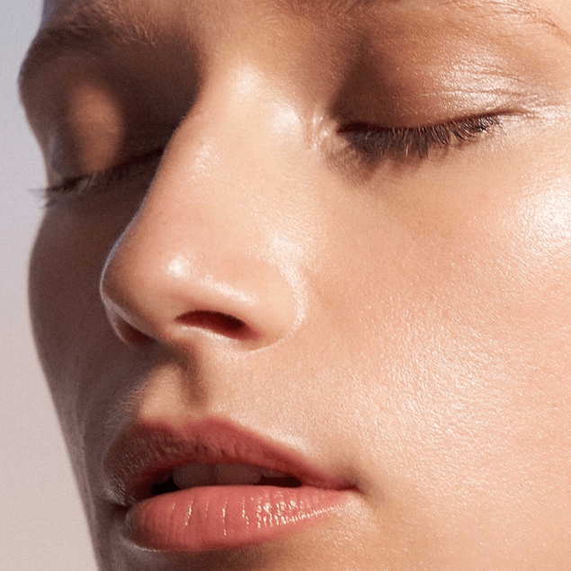 Close up of womans face glowing, eyes closed.